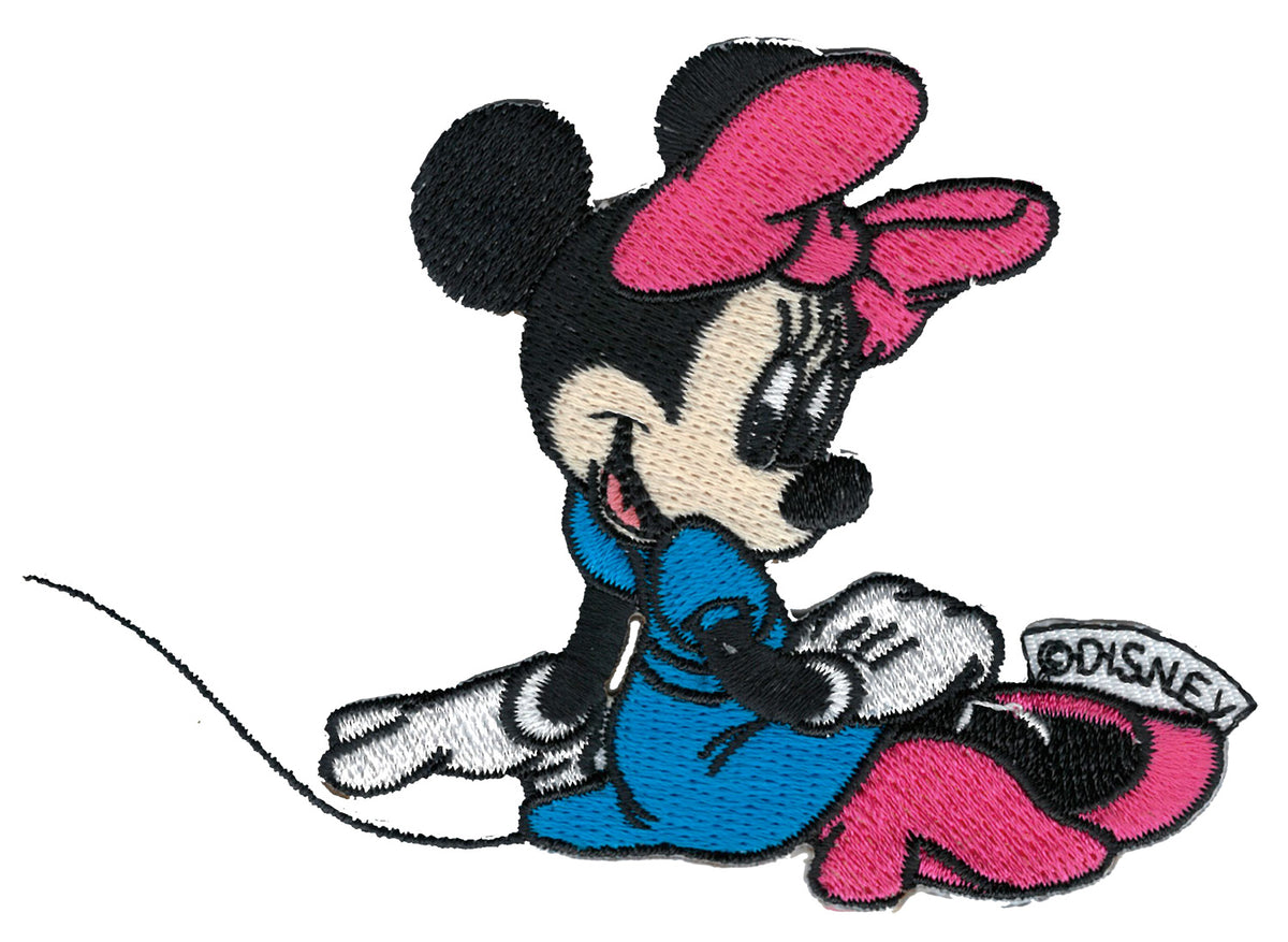 ”Broderat tygmärke med Disney Mimmi sittande i blå klänning, rosa rosett och rosa skor.”