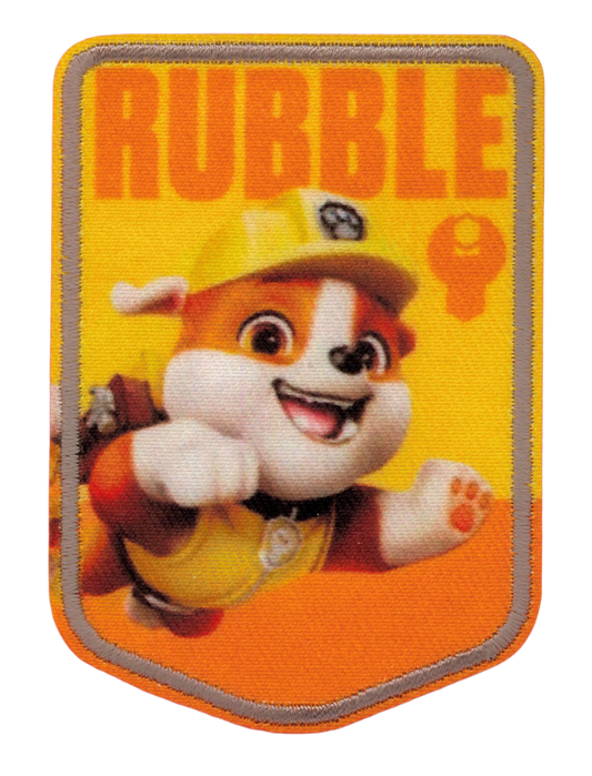 ”Paw Patrol-tygmärke med Rubble i gul bygghjälm mot gul och orange bakgrund och texten RUBBLE upptill.”